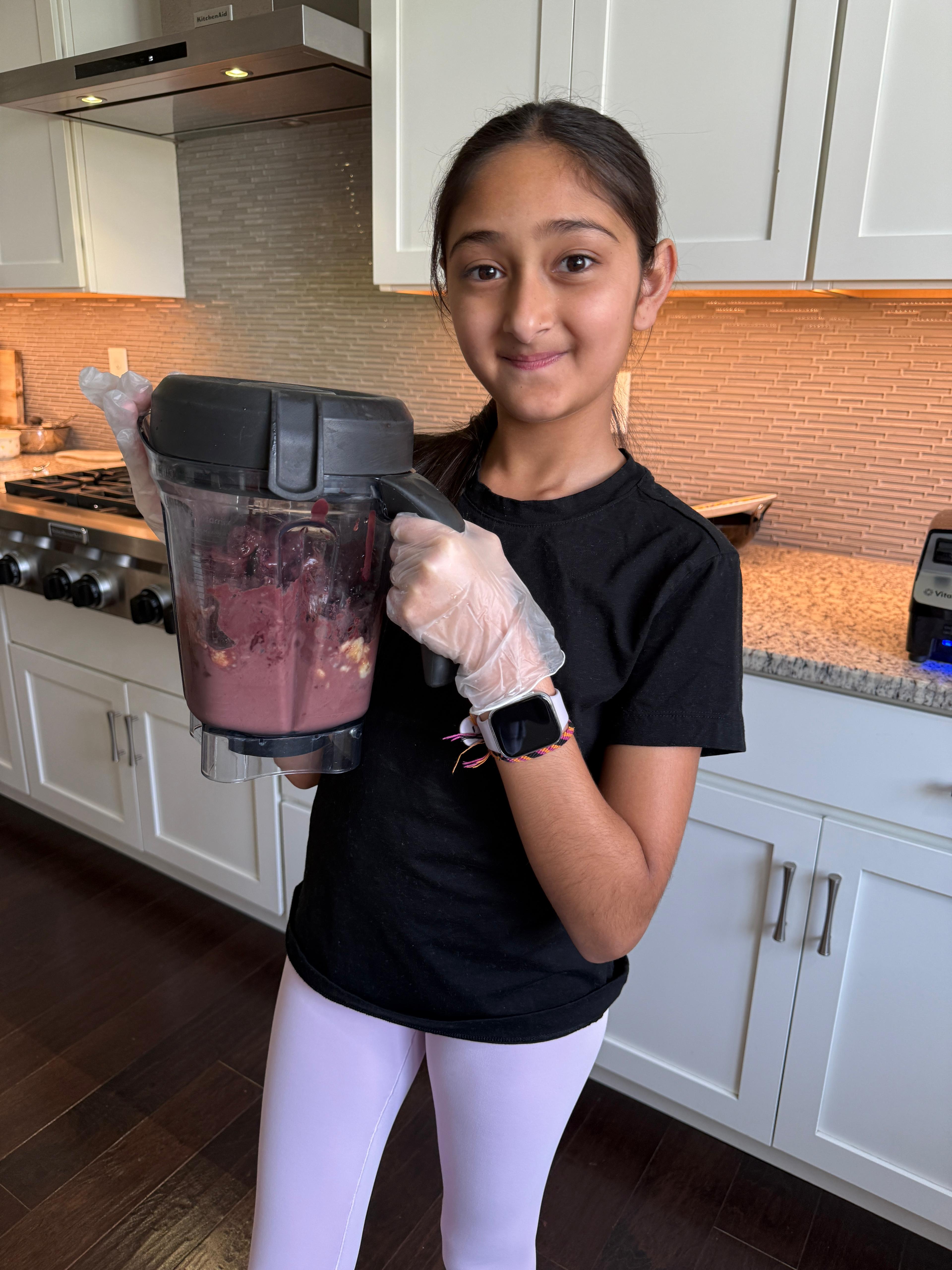 Arianna holding a blender full of açaí base mixture