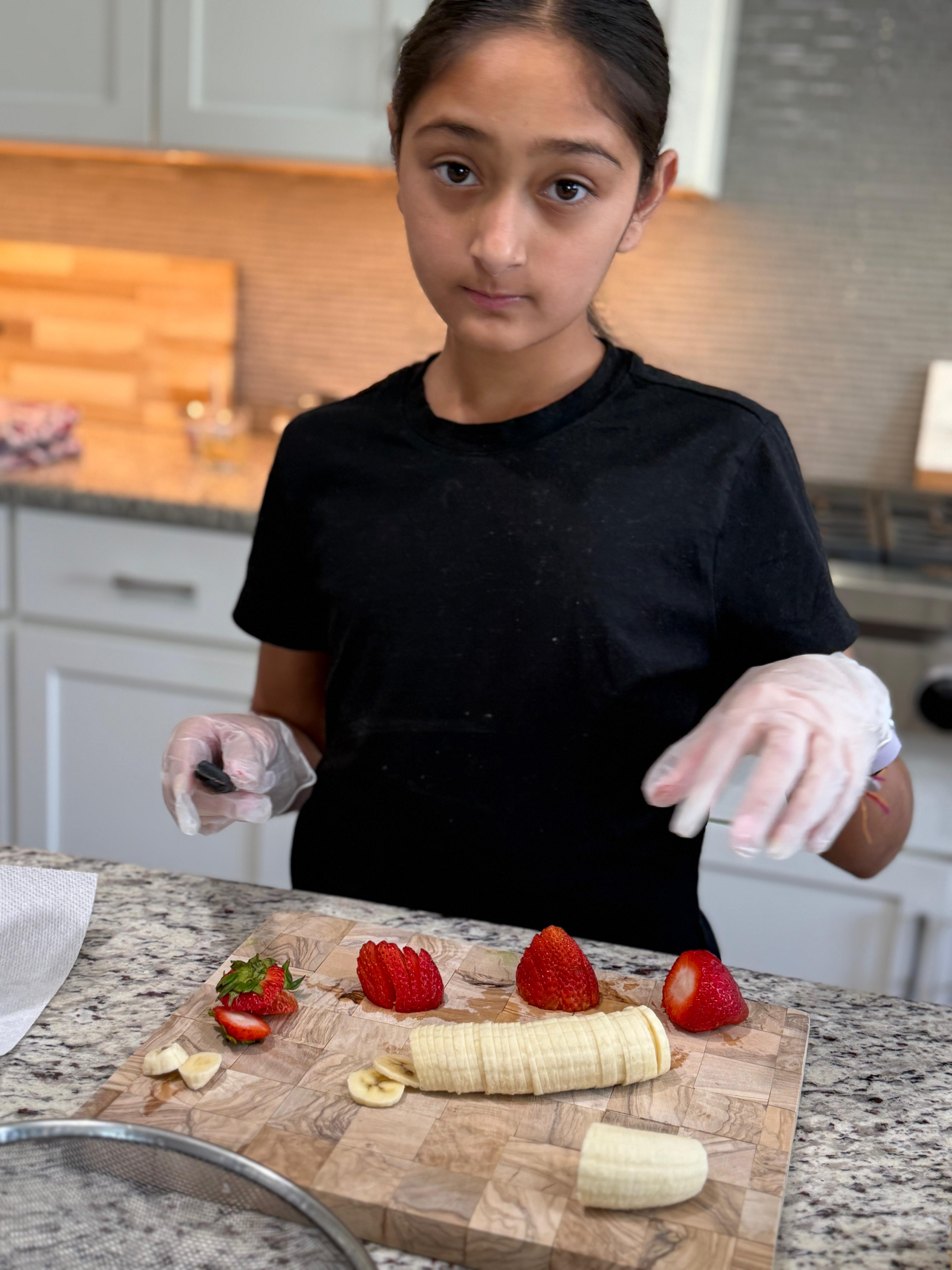 Arianna arranging fresh fruit on a cutting board